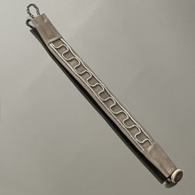 Authentique bracelet Lapon conçu et fait main en cuir de renne couleur gris perle avec un  tressage ondulé en mélange de fil d'argent et d'étain. Le fermoir est en corne de renne.
La largeur du bracelet est d'environ 1,5 cm et sa longueur totale -en comptant la boucle en cuir- est de 18 cm.